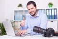 Bearded photographer at his office with laptop and camera