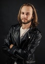 bearded rocker in leather jacket. man with long hair. rock style fashion. stylish brutal man hipster. Royalty Free Stock Photo