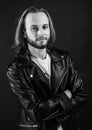 bearded rocker in leather jacket. man with long hair. rock style fashion. stylish brutal man hipster. Royalty Free Stock Photo