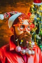 Bearded Santa Claus - close up portrait. Bearded crazy Santa looking at the camera. Christmas santa wishes merry