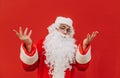 Bearded Santa Claus is expressing confusion with a hand gesture. Doubtful and thoughtful Santa is raising his hands. Red