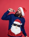 bearded santa man singing in microphone in hat smiling while prepare for celebrating happy new year party and christmas Royalty Free Stock Photo