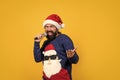 bearded santa man singing in microphone in hat smiling while prepare for celebrating happy new year party and christmas Royalty Free Stock Photo