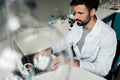 Bearded scientist using laptop in chemical laboratory