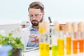 Bearded scientist working with laptop in laboratory