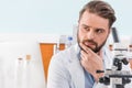 Bearded scientist working with microscope in laboratory