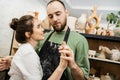 Bearded sculptor in apron holding hand