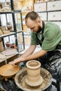 Bearded sculptor in apron washing hands