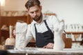 Bearded sculptor measures stone woman torso to make copy of it from limestone at creative studio.