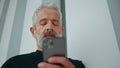 Bearded senior using mobile phone closeup. Confident brutal man wearing piercing Royalty Free Stock Photo