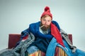 Bearded Man with Flue Sitting on Sofa at Home. Healthcare Concepts.