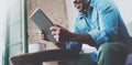 Bearded smiling African man using tablet for video conversation while relaxing on sofa in modern office.Concept of young Royalty Free Stock Photo