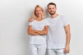 Bearded smiling handsome man hugs a woman by the shoulder on a white background