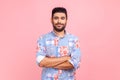 Bearded smiling man wearing blue casual style shirt standing with folded hands and looking at camera Royalty Free Stock Photo