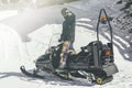 Bearded snowboarded poising on snowmobile. Snow patrol. Blurred background.Horizontal.Visual effects. Royalty Free Stock Photo