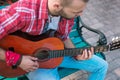 Bearded street musician practicing solo on guitar