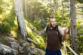 Bearded stylish hiker man using gps navigation for positioning at the mountain trail and thinks where to go. Technology Royalty Free Stock Photo