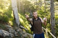 Bearded stylish hiker man using gps navigation for positioning at the mountain trail and thinks where to go. Technology Royalty Free Stock Photo