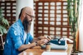 Bearded stylish writer typing on typewriter Royalty Free Stock Photo