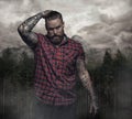 Bearded tattooed male in a red shirt.