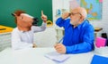 Bearded teacher and funny student in horse mask pointing finger up. Back to school. Education. Royalty Free Stock Photo