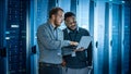 Bearded IT Technician in Glasses with Laptop Computer and Black Male Engineer Colleague are Using Royalty Free Stock Photo