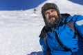 Bearded trekker resting while climbing in winter