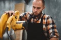 Bearded worker using electrical angular grinding machine in workshop. Servicing of machines Royalty Free Stock Photo