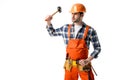 Bearded workman in orange overall and hardhat using hammer