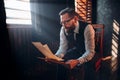 Bearded writer in glasses reads handwritten text Royalty Free Stock Photo