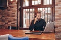 Bearded young businessman reading a newspaper and talking on a mobile phone Royalty Free Stock Photo