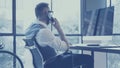 Bearded young businessman wearing white shirt,waistcoat and working at the desktop computer in modern loft.Stylish man Royalty Free Stock Photo