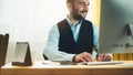 Bearded young businessman working on modern office at night. Consultant man thinking looking in monitor computer. Manager typing o Royalty Free Stock Photo