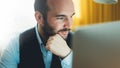 Bearded young businessman working on modern office at night. Consultant man thinking looking in monitor computer. Manager typing o Royalty Free Stock Photo