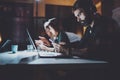 Bearded young coworker working at night office.Man using contemporary laptop and modern smartphone.Horizontal.Blurred Royalty Free Stock Photo