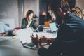 Bearded young coworker working at night office.Man using contemporary laptop and typing on modern smartphone.Horizontal Royalty Free Stock Photo