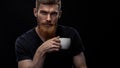 Bearded young man drinking espresso
