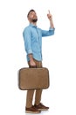 Bearded young man holding luggage, travelling and looking up Royalty Free Stock Photo