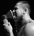 Bearded young man lick big axe foam and water splashes Royalty Free Stock Photo