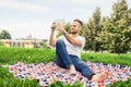 Bearded young man lying in park on blanket. He is using white ta Royalty Free Stock Photo