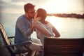 Beardy caucasian young guy kissing his woman by the sea