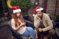 Beardy guy in company of boring female typing on her cell phone on new year party