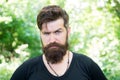 Beardy hipster. Brutal hipster on summer landscape. Bearded man in trendy hipster style outdoor. Caucasian hipster with