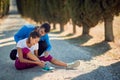 Beardy young male personal trainer comfort and advising female who injured her ankle on jogging