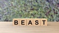 Beast - word wooden cubes on table horizontal blur background climbing green leaves