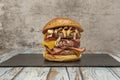 a beastly three meat burger with lots of fried bacon, cheddar Royalty Free Stock Photo