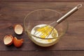 Beat fresh eggs with milk to make dough on rustic table Royalty Free Stock Photo