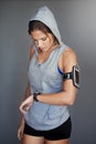 Beat your best. a sporty young woman checking the time on her sports watch against a gray background. Royalty Free Stock Photo