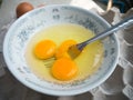Beaten raw eggs with fork in bowl Royalty Free Stock Photo