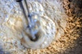 Beater swirling in mixture of dough with added flour while preparing food for baking - movement blur on beaters and shallow focus